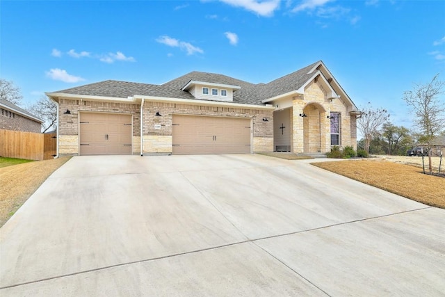 1330 Logan Blvd, Salado, TX 76571 - view of front of home with concrete driveway, stone siding, a garage, fence, and a shingled roof