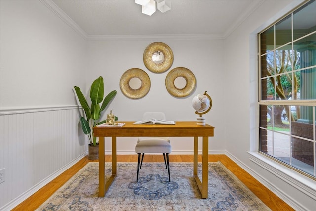 home office with a wainscoted wall, wood finished floors, and crown molding