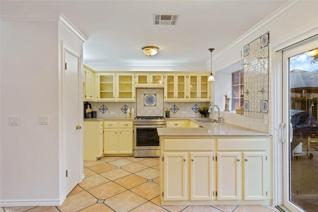 kitchen with light countertops, gas stove, glass insert cabinets, and decorative light fixtures