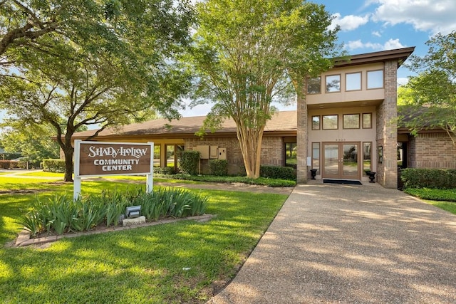 view of front of home featuring brick siding and a front lawn