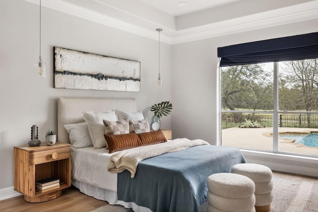 bedroom featuring baseboards, ornamental molding, and wood finished floors