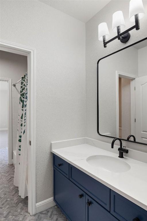 bathroom featuring shower / tub combo, vanity, and baseboards