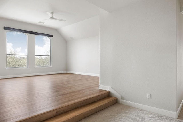 additional living space with visible vents, baseboards, a ceiling fan, lofted ceiling, and wood finished floors