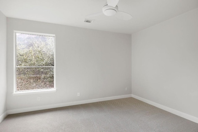 empty room featuring visible vents, carpet floors, a ceiling fan, and baseboards