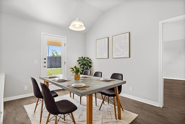 dining area featuring lofted ceiling, dark wood finished floors, and baseboards