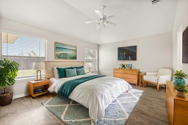 bedroom with baseboards, visible vents, a ceiling fan, wood finished floors, and vaulted ceiling
