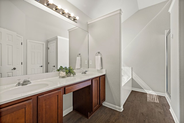 bathroom featuring double vanity, a sink, and wood finished floors