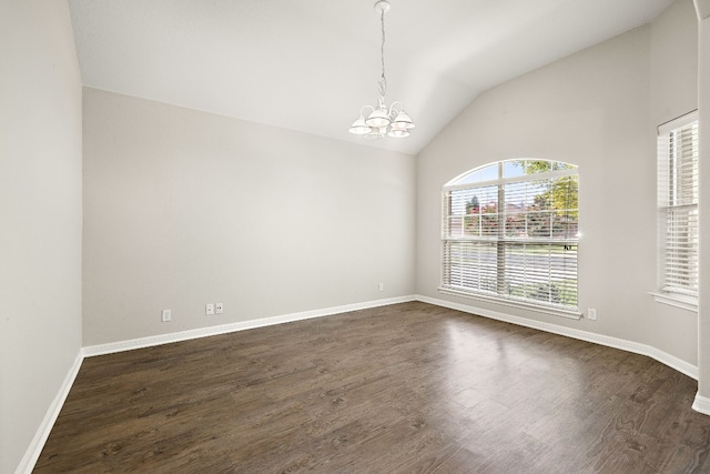 spare room with dark wood-style floors, baseboards, lofted ceiling, and a chandelier