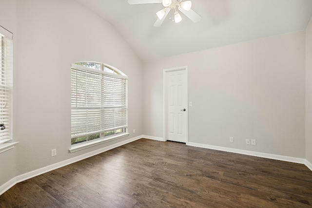 spare room with vaulted ceiling, dark wood finished floors, a ceiling fan, and baseboards