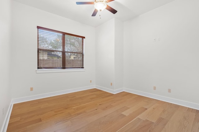 spare room with a ceiling fan, light wood-style flooring, and baseboards