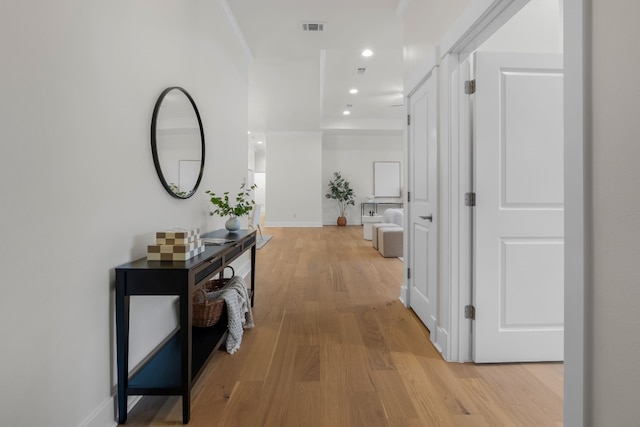 hall featuring baseboards, visible vents, ornamental molding, light wood-type flooring, and recessed lighting