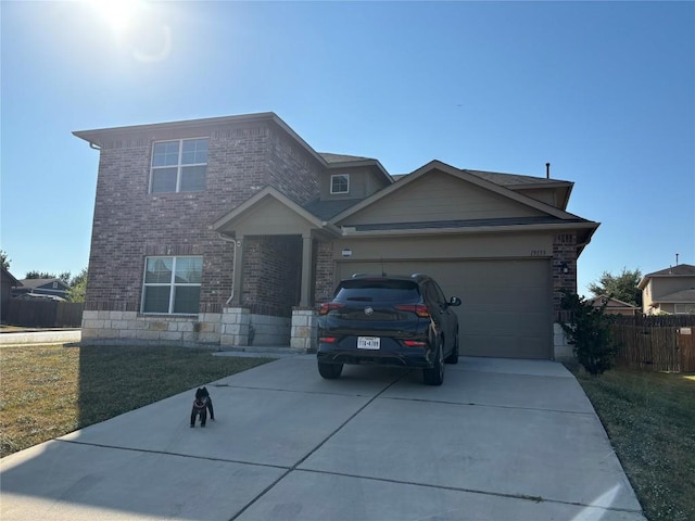 view of front facade featuring concrete driveway, a front lawn, an attached garage, and fence
