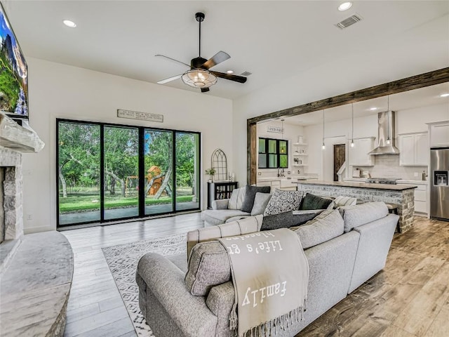 living room with a ceiling fan, recessed lighting, visible vents, and light wood-style floors