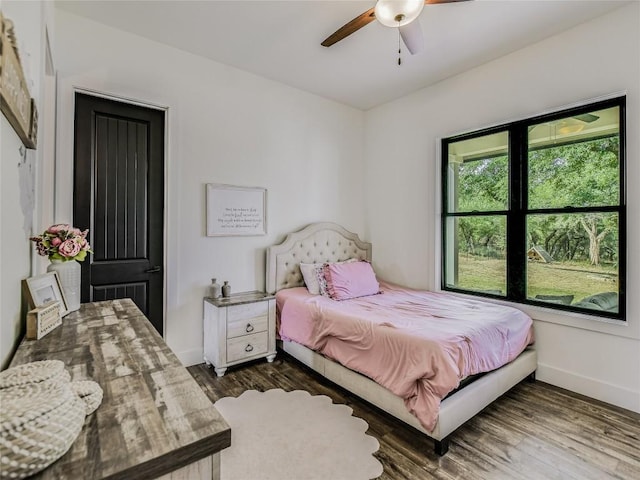 bedroom with dark wood-type flooring, ceiling fan, and baseboards