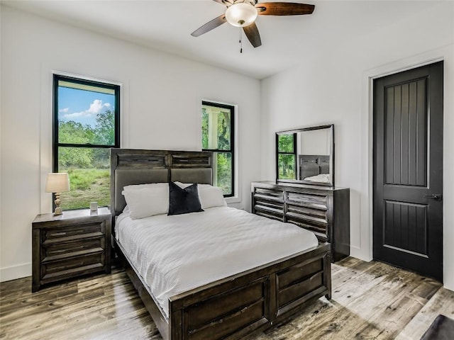 bedroom featuring light wood-style floors, baseboards, and a ceiling fan