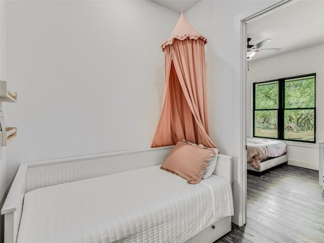 bedroom with a ceiling fan, baseboards, and wood finished floors