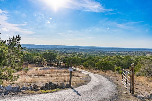 exterior space with a rural view and a gated entry