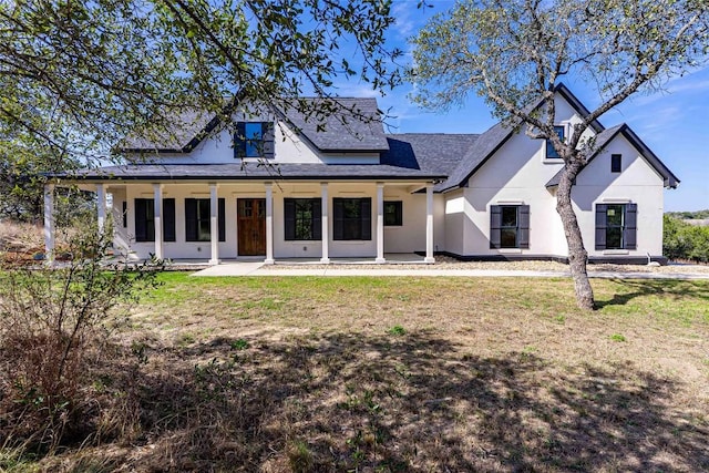 rear view of house with a yard, a porch, and stucco siding