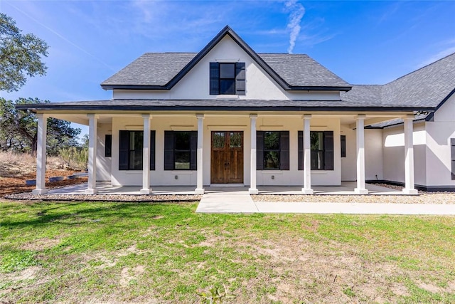 rear view of house featuring a shingled roof, a yard, and stucco siding