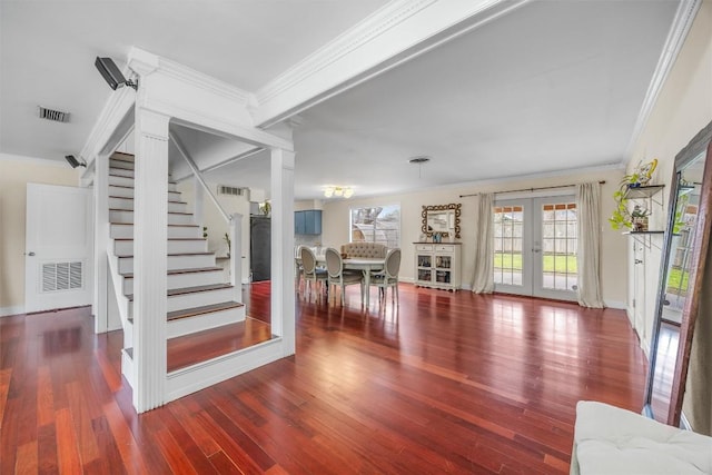 stairs with french doors, crown molding, wood finished floors, ornate columns, and baseboards