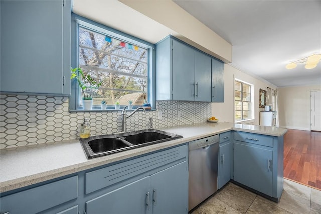 4608 Arapahoe Trl, Austin, TX 78745 - kitchen with stainless steel dishwasher, a peninsula, light countertops, and blue cabinetry