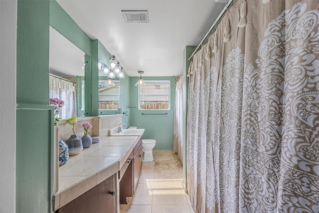 bathroom featuring toilet, vanity, and tile patterned flooring