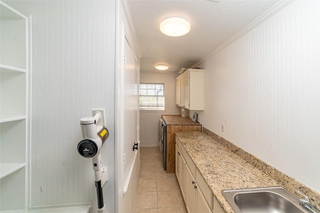 kitchen with light stone counters, open shelves, light tile patterned floors, white cabinets, and a sink