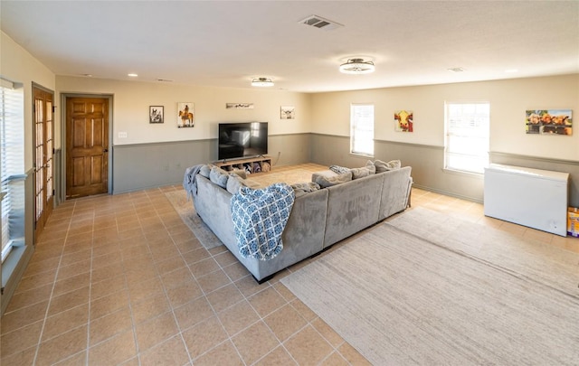 living room with wainscoting, tile patterned flooring, and visible vents