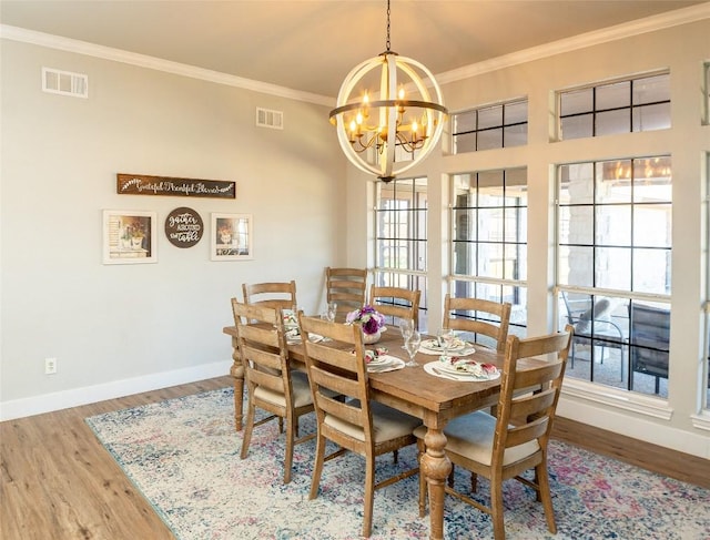 dining space with visible vents, crown molding, baseboards, and wood finished floors