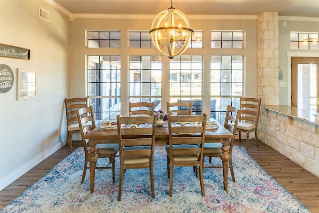 dining room with crown molding, wood finished floors, visible vents, and an inviting chandelier