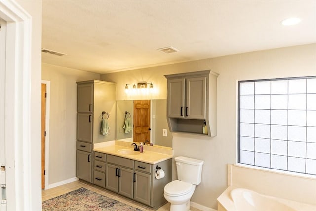 full bathroom featuring toilet, vanity, visible vents, a bath, and tile patterned floors