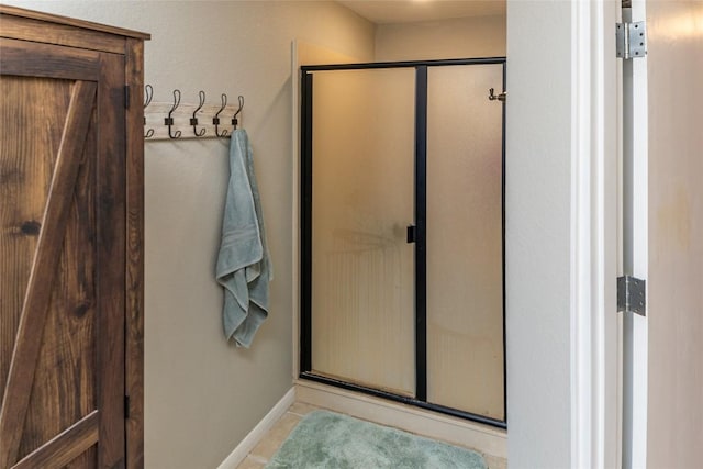 full bathroom featuring a stall shower, baseboards, and tile patterned floors