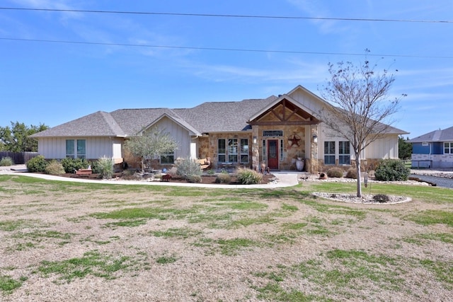 view of front facade featuring stone siding and a front yard