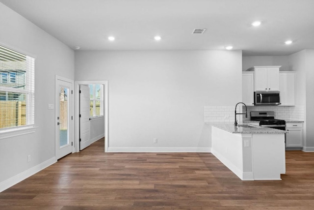 kitchen featuring stainless steel appliances, white cabinetry, a sink, and a peninsula