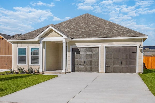 single story home featuring a shingled roof, board and batten siding, fence, a garage, and a front lawn