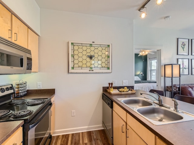 1201 Grove Blvd Unit 2803, Austin, TX 78741 - kitchen with stainless steel appliances, light brown cabinetry, a sink, dark wood-type flooring, and dark countertops