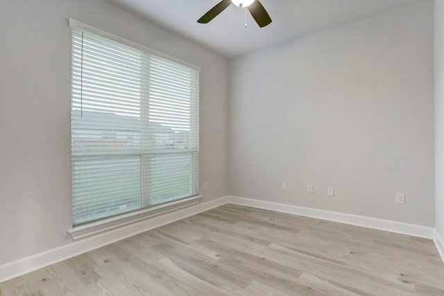 empty room featuring a ceiling fan, light wood-style flooring, and baseboards