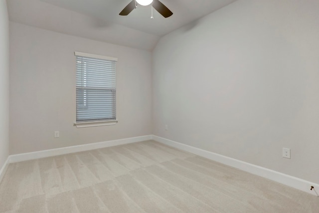 empty room featuring light carpet, baseboards, a ceiling fan, and lofted ceiling