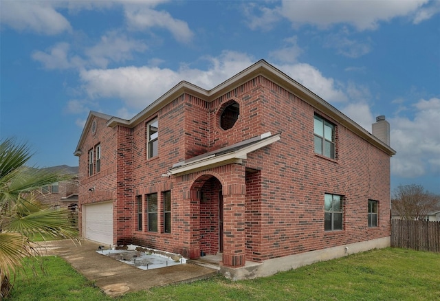 exterior space with a garage, a chimney, a front lawn, and brick siding