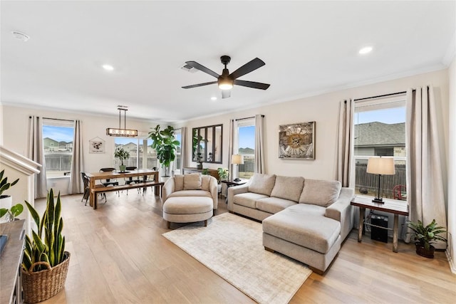 living room featuring light wood-style floors, a wealth of natural light, crown molding, and recessed lighting