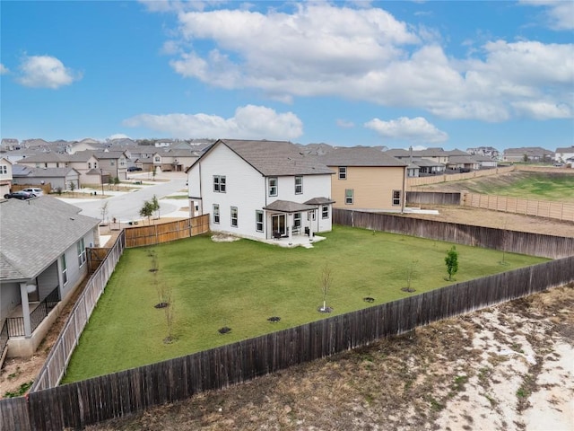 back of property featuring a fenced backyard, a residential view, and a lawn