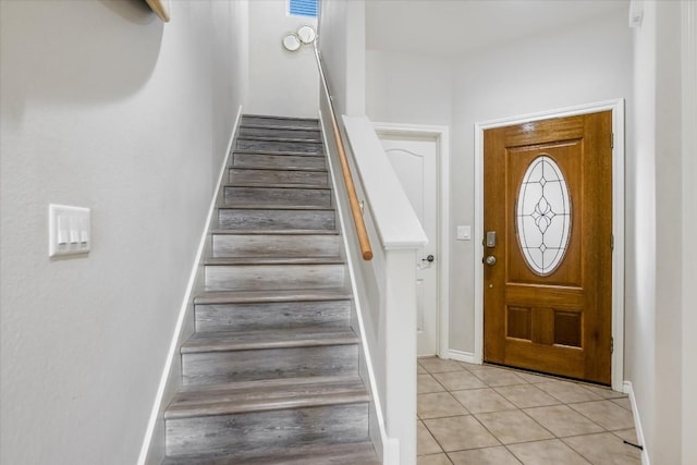 foyer entrance featuring light tile patterned floors and stairway