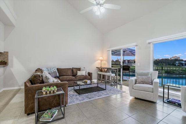 living area featuring baseboards, high vaulted ceiling, a ceiling fan, and light tile patterned flooring