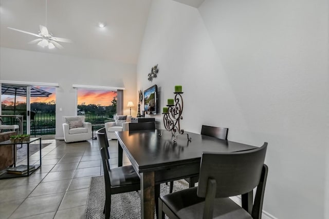 tiled dining room with high vaulted ceiling, a sunroom, ceiling fan, and baseboards