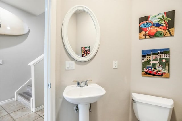 half bathroom featuring tile patterned flooring and toilet