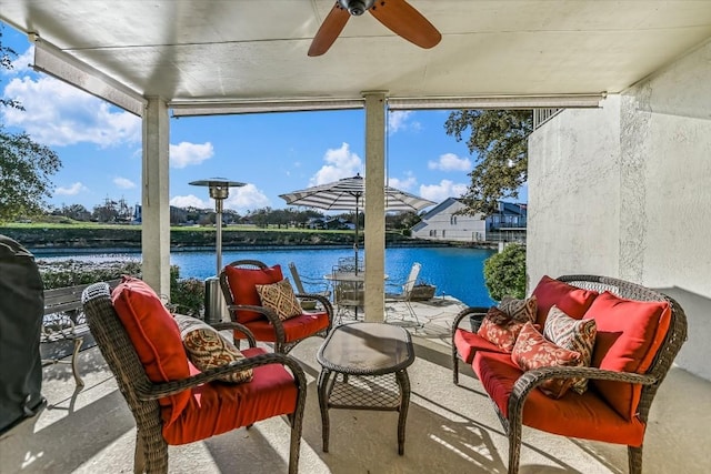 sunroom / solarium featuring a water view and a ceiling fan