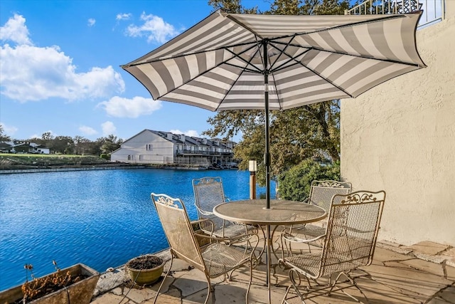 view of dock with outdoor dining space and a water view