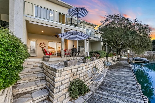 back of house featuring ceiling fan, a patio, a balcony, and stucco siding