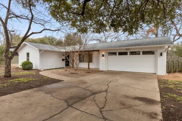 single story home featuring driveway, brick siding, an attached garage, and a shingled roof