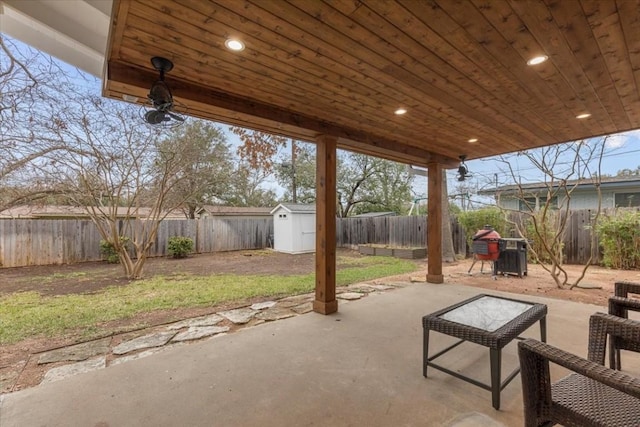 view of patio / terrace with a storage shed, a fenced backyard, and an outdoor structure